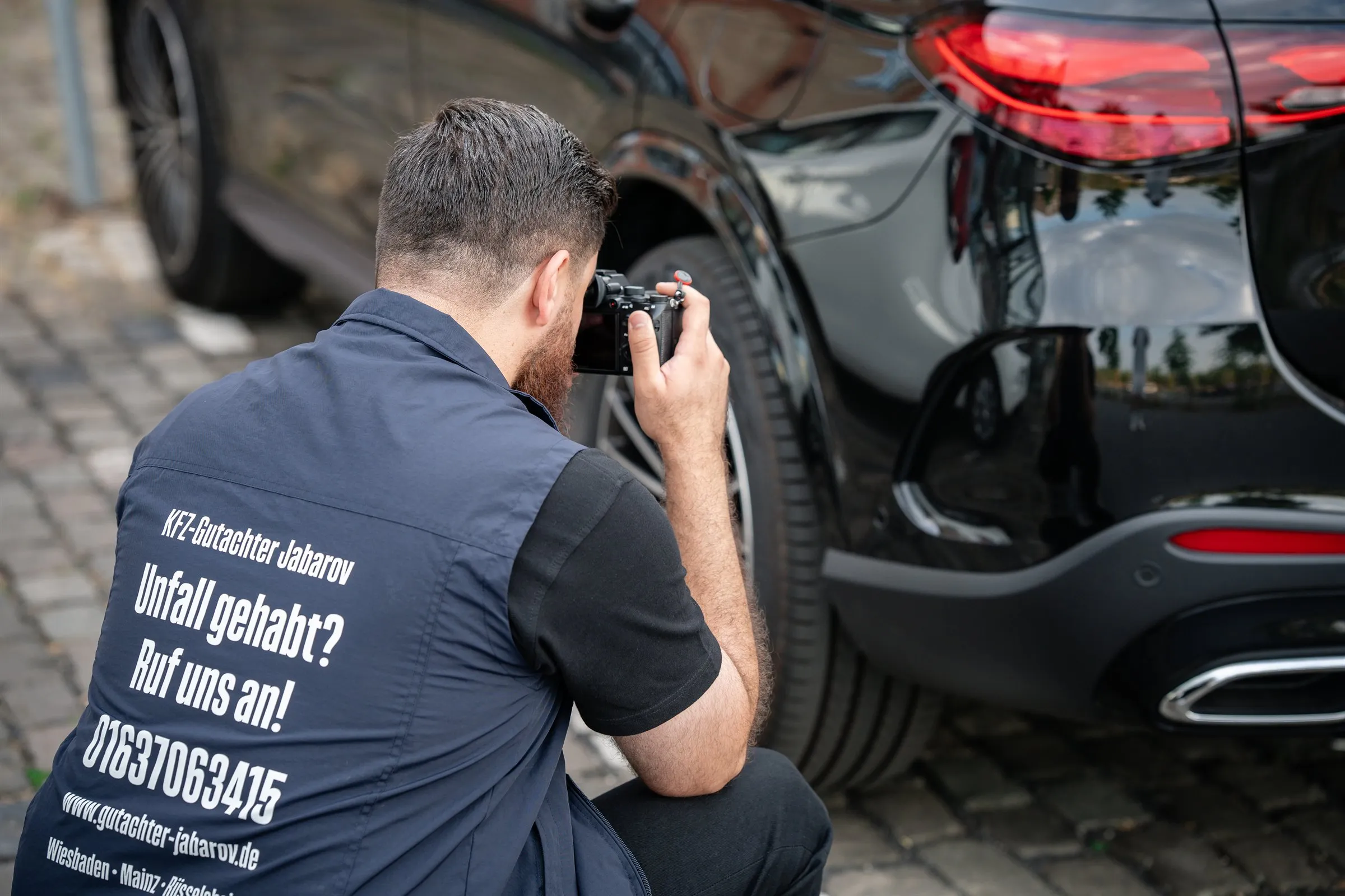 Ismayil Jabarov dokumentiert den Heckschaden einer Mercedes-Limousine